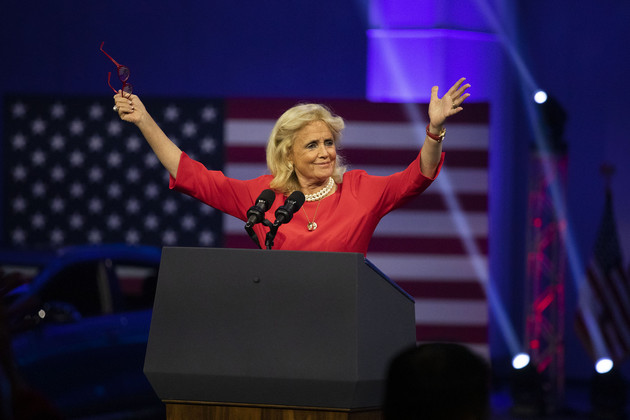 Rep. Debbie Dingell (D-MI) raising her arms while speaking at the North American International Auto Show.