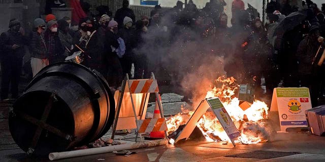 Trash burns as people take part in a protest against police brutality, Jan. 24, 2021, in downtown Tacoma, Washington.