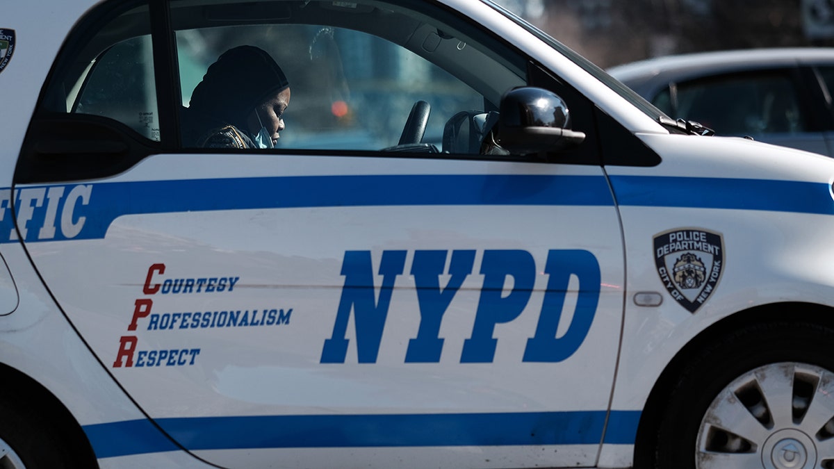 NYPD officer in marked vehicle