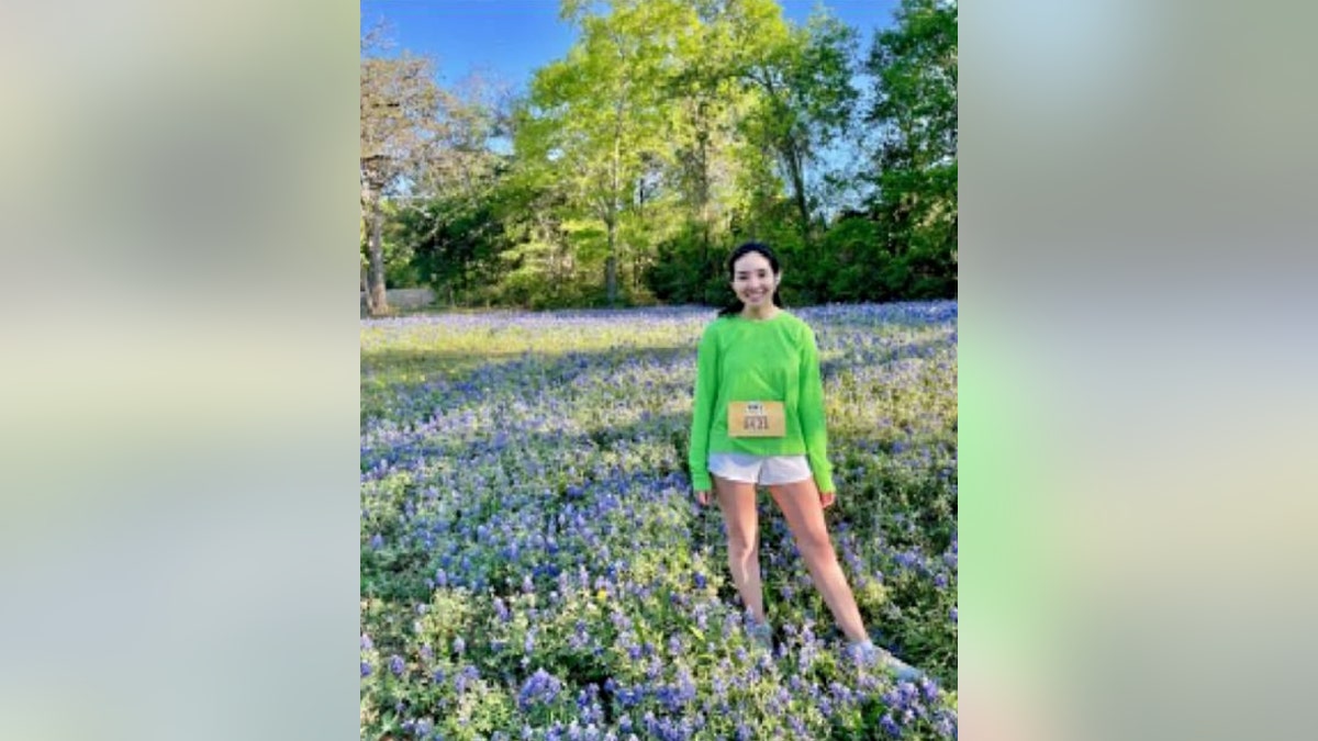 Christina Perry wearing a race bib and standing in a field of flowers