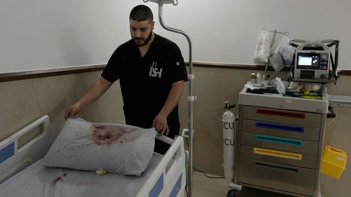 A staff member at Ibn Sina Hospital displays a blood-stained pillow following a deadly Israeli military raid in the West Bank town of Jenin