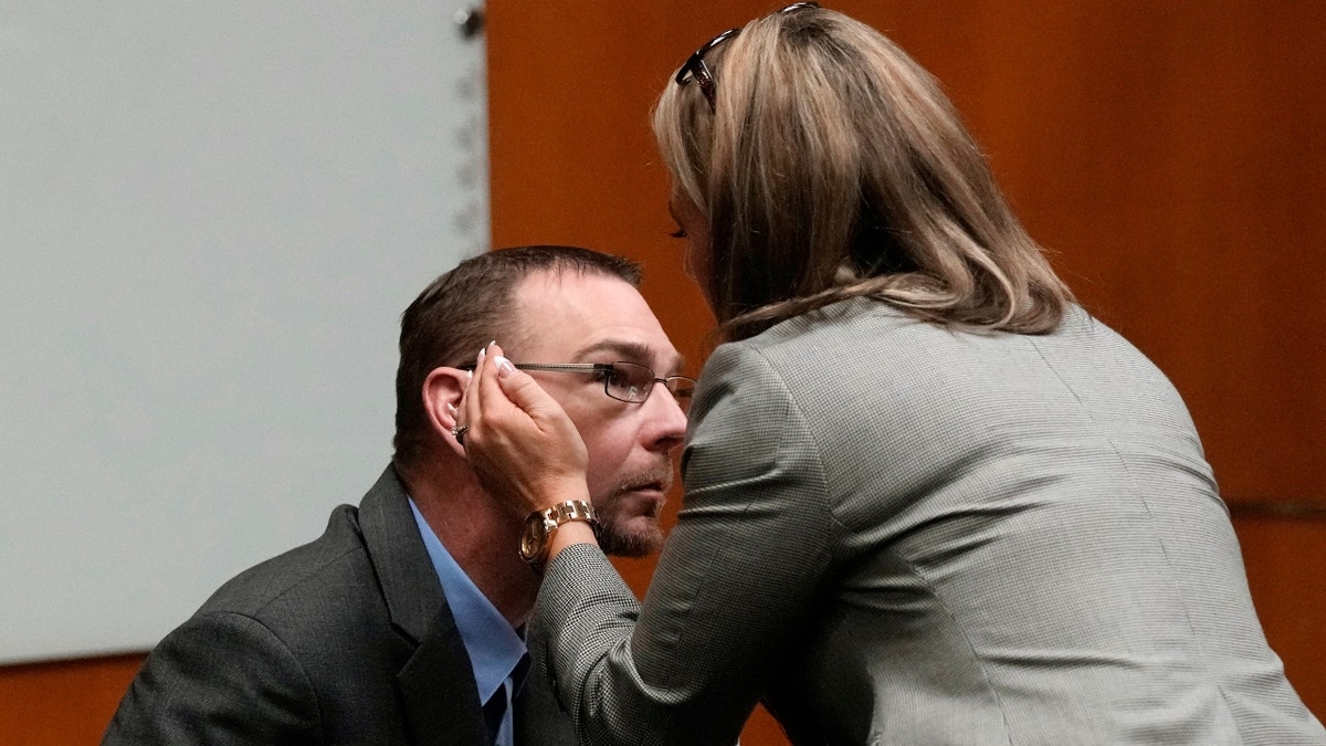 Defense attorney Mariell Lehman prepares to whisper in the ear of James Crumbley
