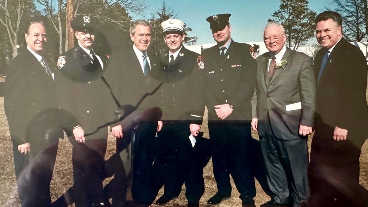 Uniformed firefighters and police officers meet with then-President George W Bush and then-US Rep Peter King