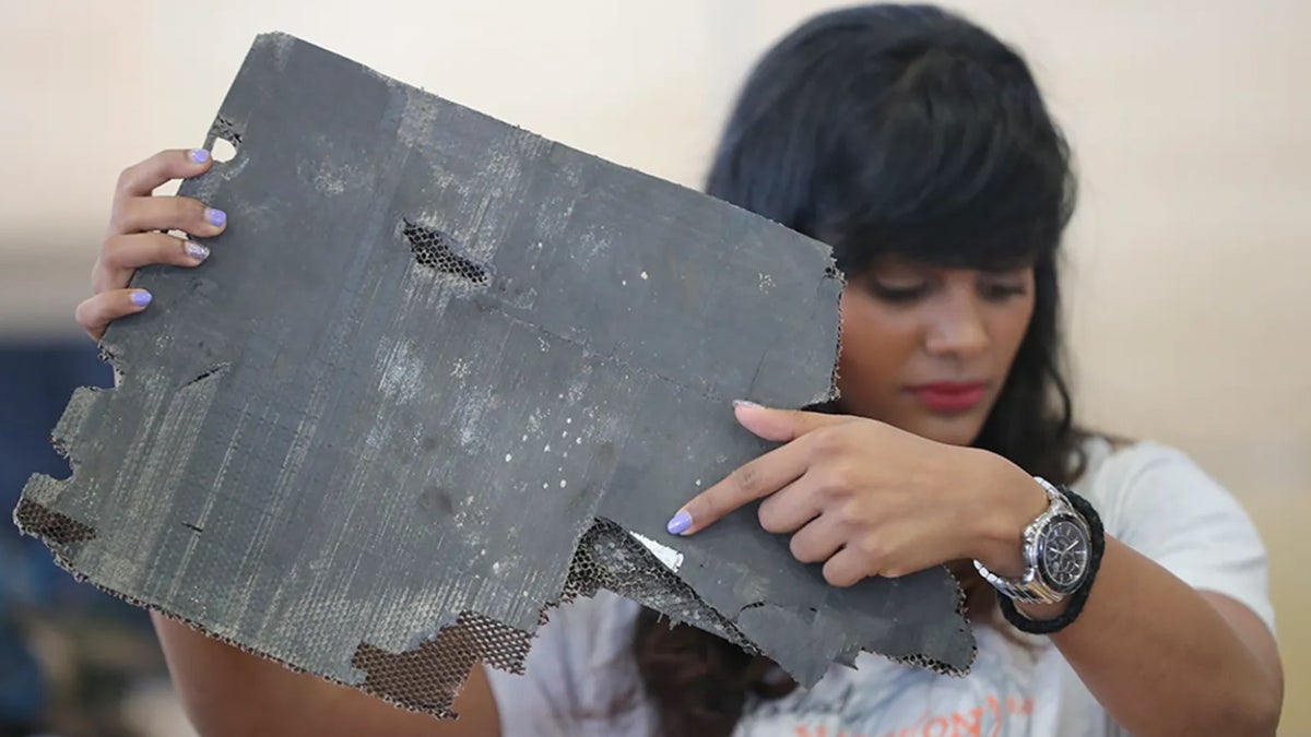 Grace Nathan, whose mother was on the ill-fated Malaysia Airlines Flight 370, shows a serial number on a piece of debris found in Madagascar that is 